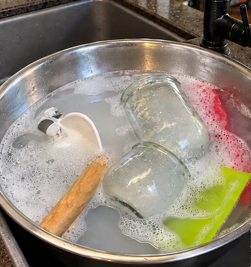 Jars, a dough hook and spatulas soaking in the bowl